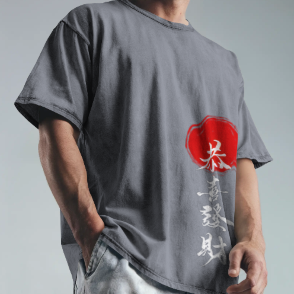 A man wearing a dark grey oversized t-shirt featuring Naruto bold white kanji text vertically aligned with a striking red stamp design. The background is neutral, keeping focus on the shirt’s design.